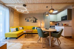 a living room with a yellow couch and a table at Vila Roháčka - Luxusná Vila so súkromným wellness a bazénom in Habovka