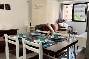 a living room with a table with chairs and a couch at Lindo Flat a poucos passos da praia in Maceió