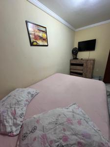 een slaapkamer met een bed en een flatscreen-tv bij Apê Dunas do Forte in Cabo Frio +3 foto's