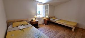a small room with two beds and a window at Malicroix in Arles