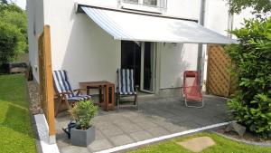 awning over a patio with two chairs and a table at Ferienwohnung Jürgens in Rheinbreitbach