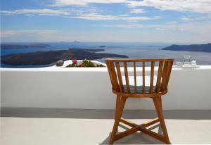 a wooden chair sitting on top of a white wall at Olea Cave House in Imerovigli