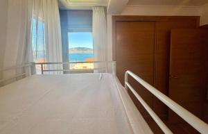 una camera da letto con un letto grande e una finestra di Holibai, Son do Mar Son do Mar, Lujo sereno frente al Atlántico, Baiona a Baiona Altre 24 foto