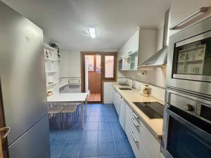 una cucina con armadi bianchi e pavimento piastrellato blu di Holibai, Son do Mar Son do Mar, Lujo sereno frente al Atlántico, Baiona a Baiona