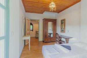 SkiathosにあるLago Skiathos Art Residency & Guesthouseのベッドと机とテーブルのある寝室