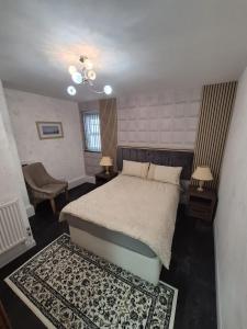 a bedroom with a bed and two tables and a chair at Ulverston Town Centre Flat (2 Bedrooms) in Ulverston