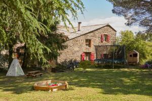 a house with a picnic table and a tent in the yard at La Cabane de l'Orpailleur in Gravières