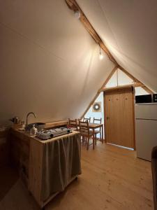 a kitchen in a tent with a table and a sink at La Cabane de l'Orpailleur in Gravières