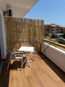 een tafel en stoelen op een balkon met een raam bij Skiathos Bliss Villa in Skiathos-stad +7 foto's