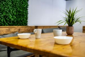 een houten tafel met drie witte kommen erop bij Heart of the city Hostel in Varna +56 foto's