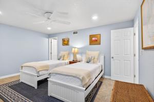 una camera da letto con due letti e un ventilatore a soffitto di Beachfront Aldea 11 a Clearwater Beach Altre 44 foto