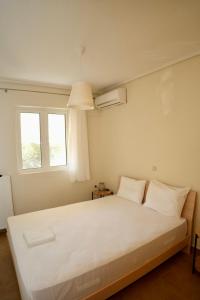 une chambre avec un grand lit blanc avec deux oreillers dans l'établissement Casa Vardani Modern Central Apartments 2, à Leucade