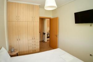 une chambre avec un lit et une télévision à écran plat dans l'établissement Casa Vardani Modern Central Apartments 2, à Leucade