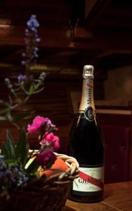 a bottle of champagne next to a basket of flowers at Nereid in Nisída Ágios Nikólaos