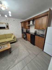 a living room with a couch and a kitchen at Ulverston Town Centre Flat (2 Bedrooms) in Ulverston