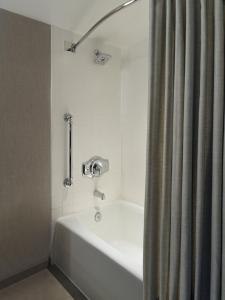 a white bath tub with a shower curtain in a bathroom at Marriott at the University of Dayton in Dayton