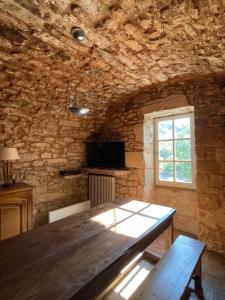 a dining room with a wooden table and a window at Les Grottes in Sivergues