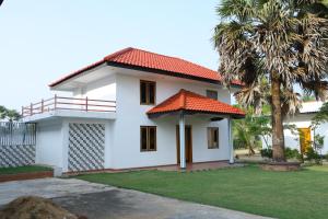 a white house with an orange roof at Palmyra Resort Jaffna in Jaffna