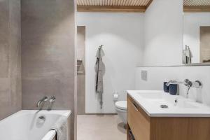 a bathroom with a tub and a sink and a toilet at 1174-Ringkobing-Jagtvej-34-C-lejl-5 in Ringkøbing +54 photos