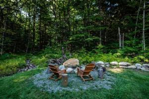 a group of chairs sitting around a fire pit at Dream Stratton Forest Cabin with Hot Tub and Fast WiFi in Stratton