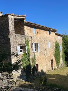 an old stone building with ivy growing on it at Les Grottes in Sivergues