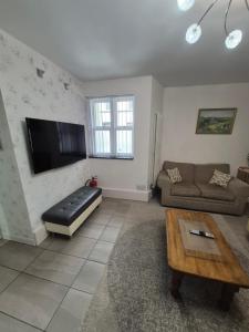 a living room with a couch and a flat screen tv at Ulverston Town Centre Ground Floor Apartment in Ulverston