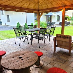 a patio with a table and chairs and a table and bench at Willa Roztocze in Zwierzyniec