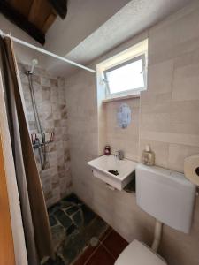 a bathroom with a sink and a toilet and a window at Campinho Guest house in Campinho