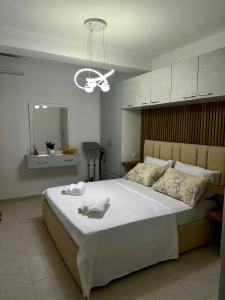 a bedroom with a large bed with two towels on it at Hill Escape Durres Vollga Apartment in Durrës