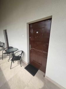 a large wooden door with a table and chairs next to it at Cichy Zakątek in Bobolin