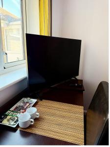 a desk with a computer monitor and two cups on it at Simplystay Lincoln Road in Skegness