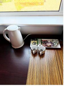 a table with a coffee pot and a box of food at Simplystay Lincoln Road in Skegness