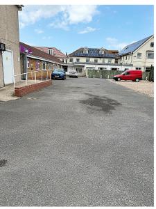 an empty parking lot with cars parked in front of buildings at Simplystay Lincoln Road in Skegness +14 photos