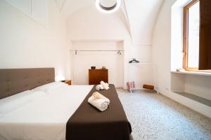 a bedroom with a large white bed with towels on it at La Fontana Casaurea Apartment, Centro-AC in Villa Castelli