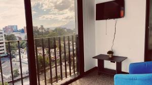 a room with a balcony with a view of a city at Apartamento Zona 10 in Estación Pamplona