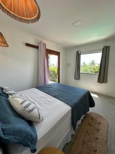 a bedroom with a bed and a window at Morada do Vento in Guriú