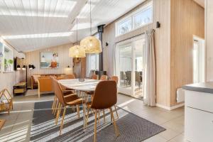 a kitchen and dining room with a table and chairs at 1129-Ringkobing-Irisvej-11 in Nørby