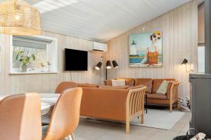 a living room with a couch and a table and chairs at 1129-Ringkobing-Irisvej-11 in Nørby
