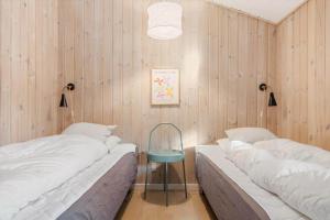 two beds in a room with wooden walls at 1129-Ringkobing-Irisvej-11 in Nørby
