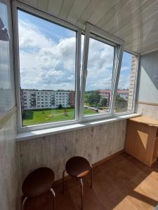 two chairs sitting in a room with two windows at Rancāna ielas 5 stāva apartamenti in Rēzekne