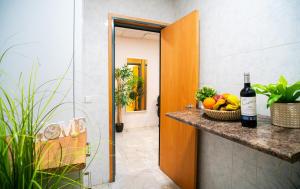 Una habitación con un mostrador con una cesta de fruta y una botella de vino. en Luxury Light Apartment - Malaga Center, en Málaga