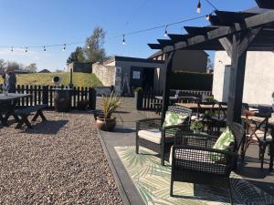 a patio with a table and chairs and a pergola at Pitlessie Rooms at Pitlessie Village Inn in Pitlessie