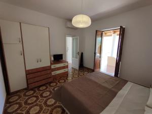 a bedroom with a bed and a dresser and a mirror at Eoliando Case per Vacanze - Lipari Mare in Lipari