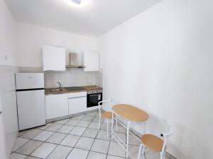 a kitchen with white cabinets and a table and chairs at Eoliando Case per Vacanze - Lipari Mare in Lipari +22 photos