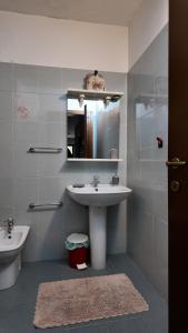 a bathroom with a sink and a mirror and a toilet at Whole apartment in Villa surrounded by green in Colleverde
