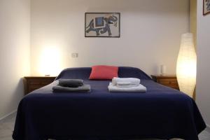 a bedroom with a blue bed with towels on it at Whole apartment in Villa surrounded by green in Colleverde