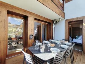 a dining room with a table with white plates on it at Homency - Résidence Parenthese A28 in L'Alpe-d'Huez +18 photos