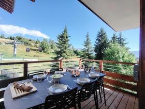 a table on a deck with a view of the mountains at Homency - Résidence Parenthese A28 in L'Alpe-d'Huez