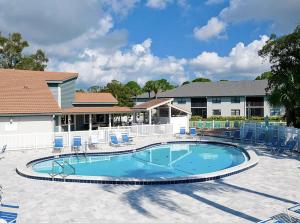 a large swimming pool with chairs and a building at MyCataleya Beautiful Florida Condo (Bradenton) in Bradenton
