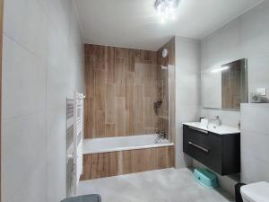 a bathroom with a bath tub and a sink at Homency - Résidence Parenthese A28 in L'Alpe-d'Huez